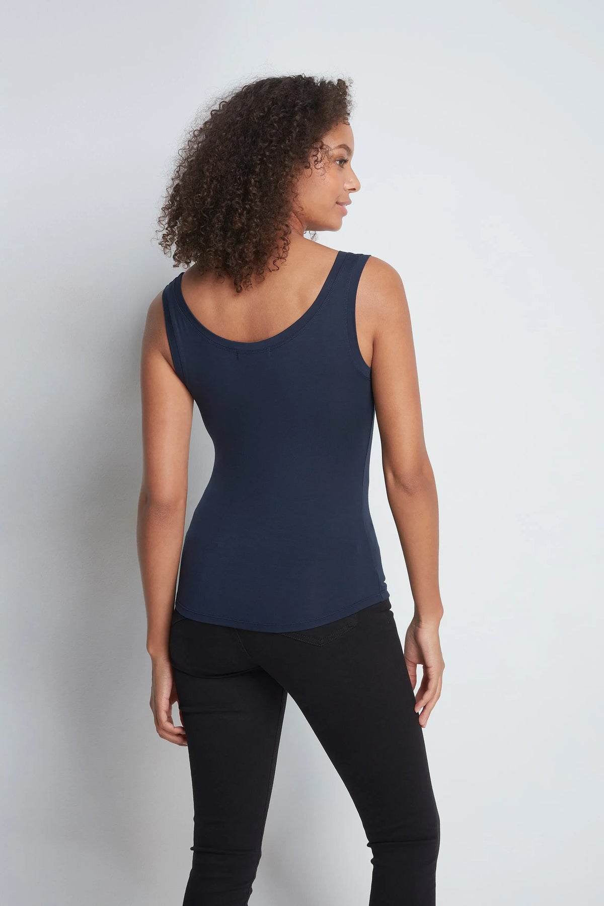 The Keep Warm Layering Gift: navy sleeveless vest top worn, back view
